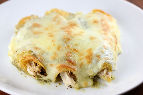 Close-up of green chicken enchiladas with melted cheese