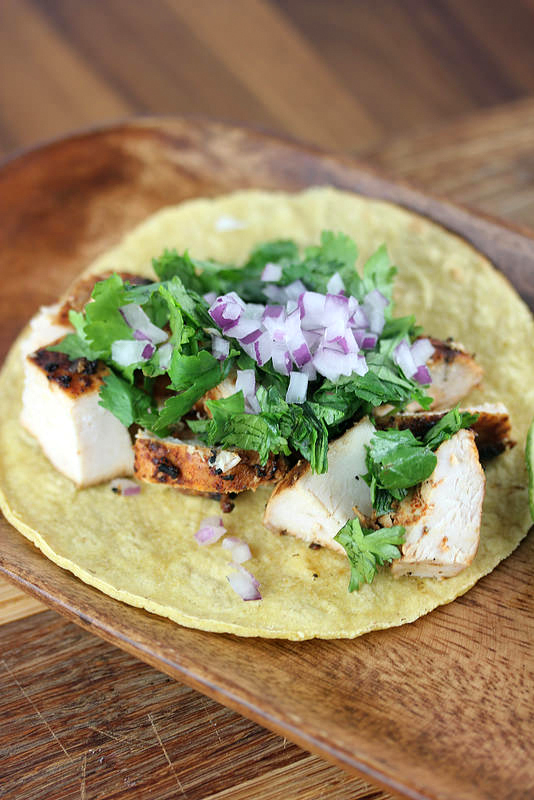 Grilled chicken street taco with onions and cilantro on a tortilla