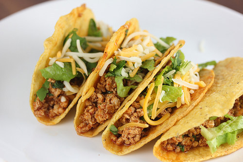 Ground chicken tacos topped with lettuce and cheese