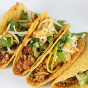 Plate of ground chicken tacos with cheese and lettuce
