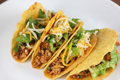 Plate of ground chicken tacos with cheese and lettuce