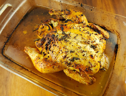 Golden roasted whole chicken with lemon and rosemary seasoning