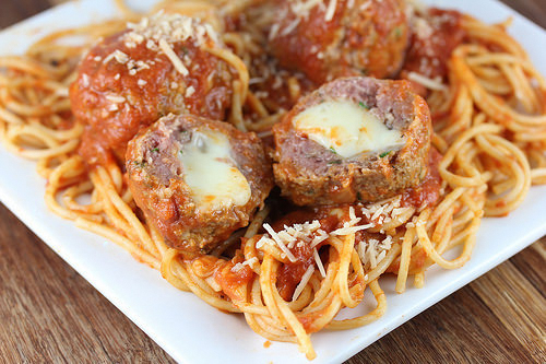 Mozzarella stuffed meatballs served over spaghetti with marinara