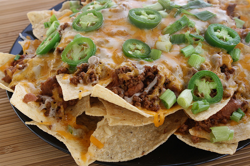 Nachos piled high with beef cheese jalapeños and green onions