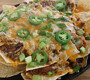 Loaded nachos with melted cheese and sliced jalapeños