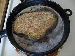 Breaded chicken frying in oil