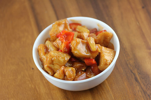 Sweet sticky chicken with pineapple and red peppers served in a bowl