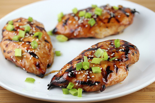 Glazed asian grilled chicken on white plate