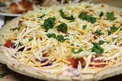 Baja chicken pizza topped with cheese and herbs
