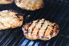 Chicken patties grilling over open flame