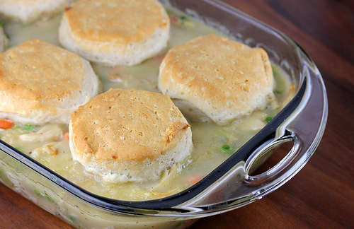 Golden biscuit topped chicken casserole in glass dish