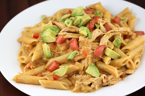 Chicken enchilada pasta topped with avocado