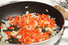Diced onions and peppers sautéing in pan