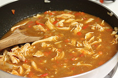 Chicken simmering in enchilada sauce
