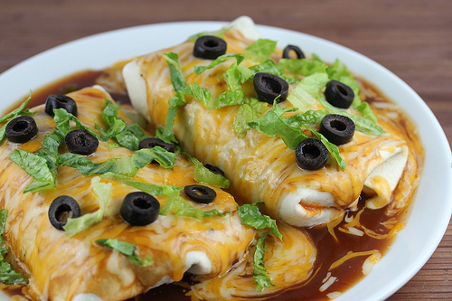 Smothered chicken burritos with lettuce and olives