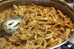 Shredded chicken filling cooking in skillet