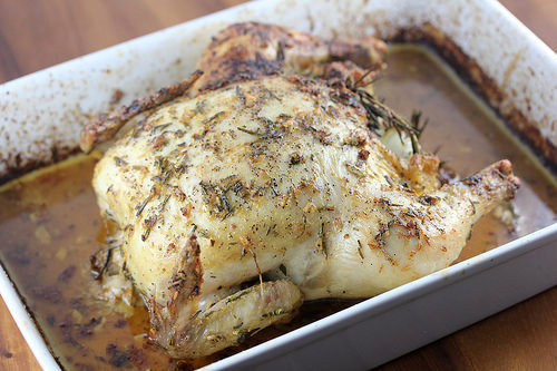 Lemon garlic roast chicken resting in a baking dish
