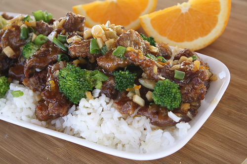 Close-up of orange beef with broccoli and citrus garnish