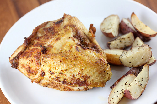 Juicy roasted chicken breast with crispy edges and potatoes