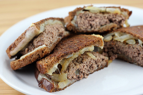 Instructions In a large skillet melt 4 tablespoons of butter over medium-high heat. Add onions and sauté until lightly browned. Remove from the pan and set aside. Form ground beef into 4 patties. Season on both sides with salt and pepper. Place into the skillet and cook hamburger patties over medium-high heat until the burgers are fully cooked (they have reached an internal temperature of 160 degrees). Heat another skillet to medium heat. Butter one side of the bread. Put the buttered side down on the hot skillet. Place 1 slice of cheese followed by onions, then add the cooked patty and top with another slice of cheese. Butter another slice of bread and place on the top buttered side out. Fry until the bread is browned and crisp on the bottom and turn over and fry until the other side is browned and crisp. The cheese should be melted. Repeat until all of the patty melts are cooked.