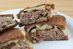 Close up of patty melt with melted cheese and onions
