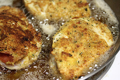 Pepperoni stuffed chicken frying in skillet