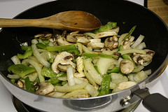 Onions and peppers sautéing in a skillet