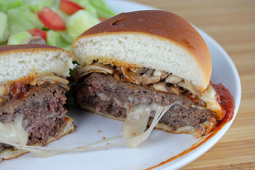 Pizza burger sliced open showing melted cheese