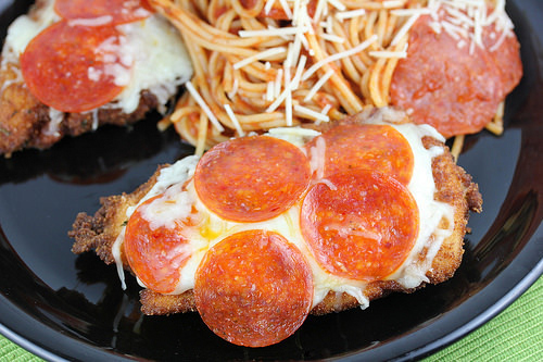 Pizza chicken topped with melted cheese and pepperoni served with spaghetti