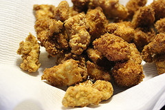Crispy fried popcorn chicken draining on paper towel