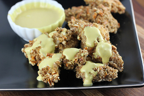 Crunchy pretzel chicken bites on black plate