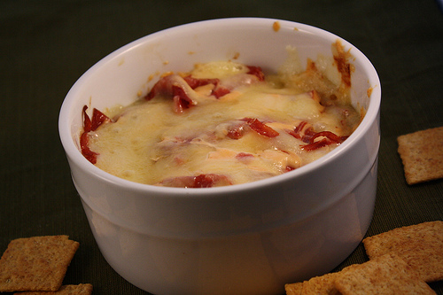 Creamy baked Reuben dip in a white ramekin with crackers
