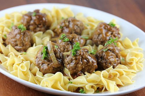 Close-up of salisbury steak meatballs on buttered egg noodles