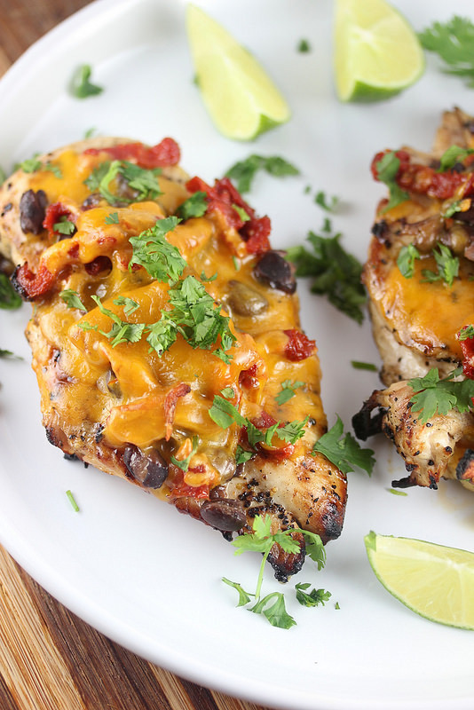 Santa Fe–style chicken on a plate with melted cheese, herbs, and lime slices