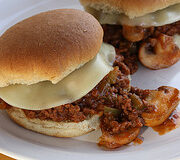 Two cheesy sloppy joe sandwiches on plate
