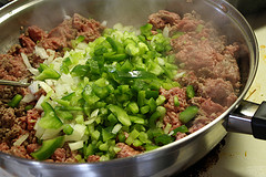 Ground beef with chopped peppers cooking in pan