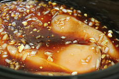Chicken cooking in asian sauce in slow cooker