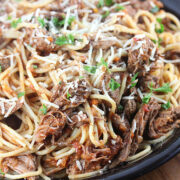 Close-up of spaghetti with slow-cooked beef ragu and herbs