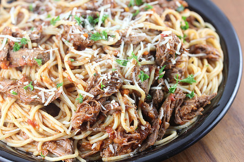 Close-up of spaghetti with slow-cooked beef ragu and herbs