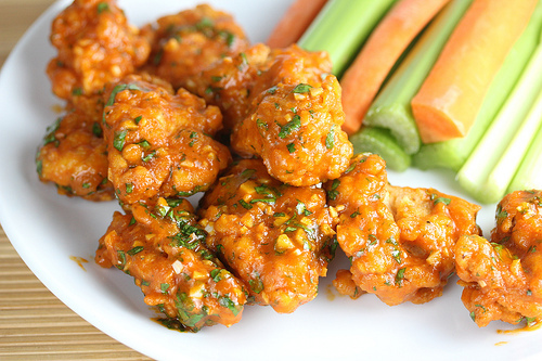 Saucy sriracha chicken wings on white plate