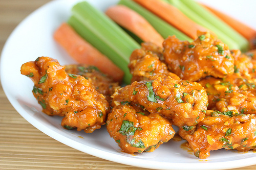 Sriracha chicken wings with celery and carrots
