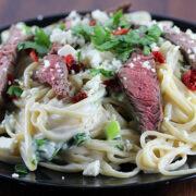 Creamy steak gorgonzola pasta on black plate
