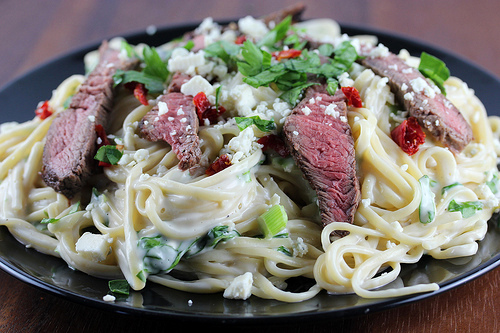 Creamy steak gorgonzola pasta on black plate