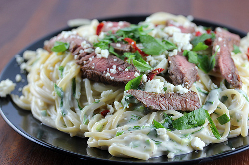 Steak gorgonzola pasta topped with fresh herbs