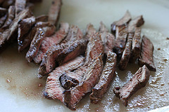 Sliced cooked steak on cutting board