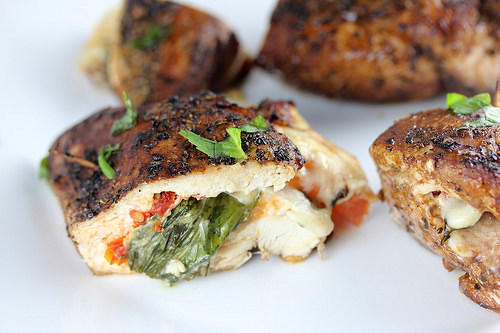 Seared stuffed chicken pieces on white plate