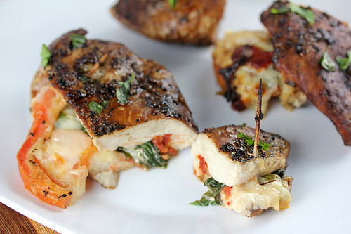 Sliced stuffed chicken with melted cheese and tomato