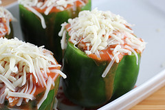 Unbaked stuffed green peppers topped with cheese