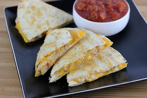 Chicken quesadillas arranged on black plate