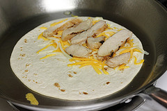 Chicken and cheese quesadilla cooking in skillet
